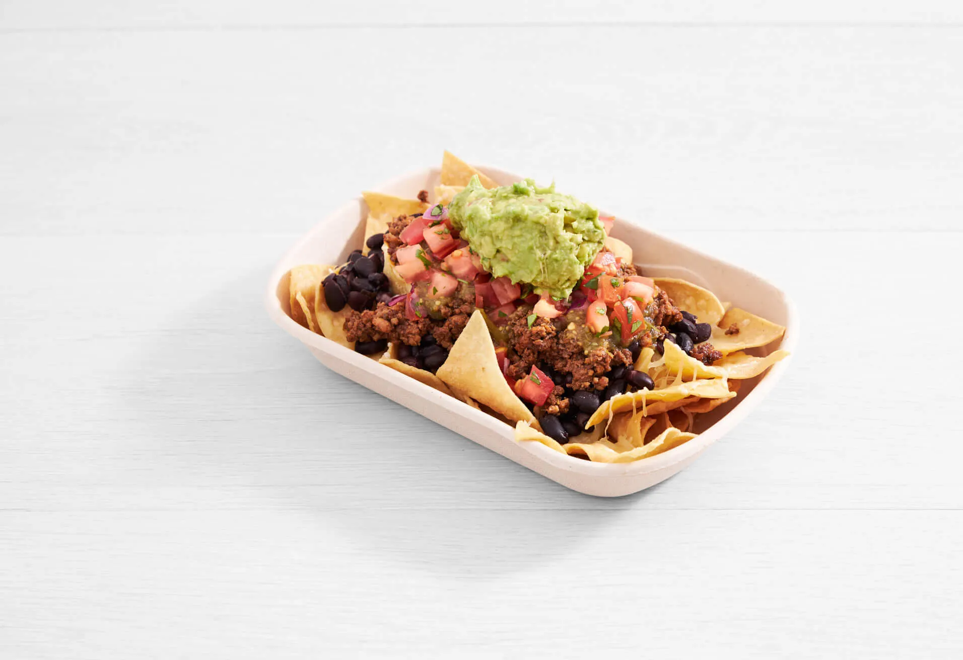 a bowl of nachos with salsa and guacamole