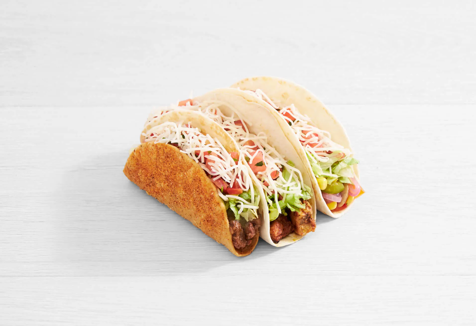 a group of tacos on a white surface