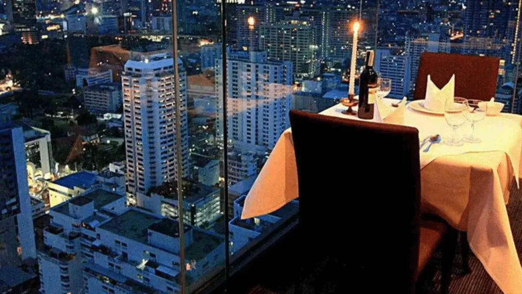 Is Sky-High Dining Worth It? The Truth at 81 Floors Up 4 Fine dining setup overlooking a glowing city skyline from 81 floors above.